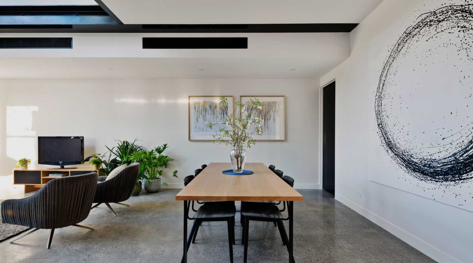 Modern dining area with black linear slot diffusers supplying ducted air conditioning