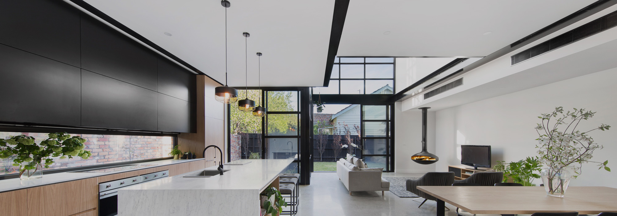 Open plan kitchen and living area with ceiling ducted air conditioning grilles